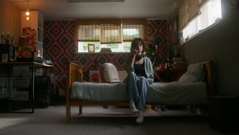 young woman talking on the phone in her bedroom