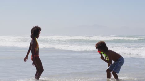 african american children wearing scuba goggles playing at the beach