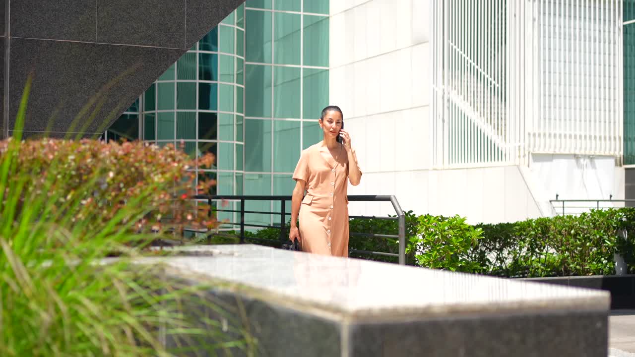 사업가 여성이 야외에서 전화로 이야기하고 있습니다.