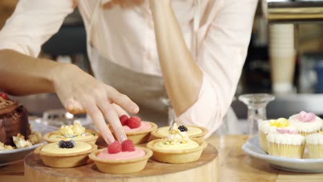 female waitress arranging sweet foods at counter 4k