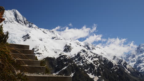 Wolke-Rollt-über-Schneebedeckten-Berg-Mit-Treppen-Im-Vordergrund