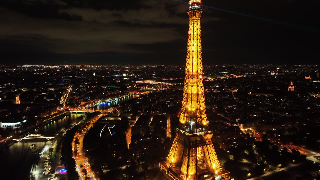 cumbre de la torre eiffel con haces de luz automáticos brillantes, paisaje urbano de parís y horizontes por la noche, vista aérea