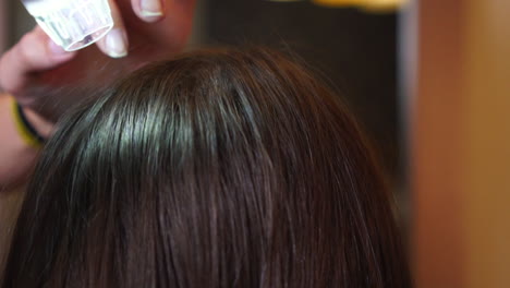 una mujer analizando la fuerza del cabello con un microscopio