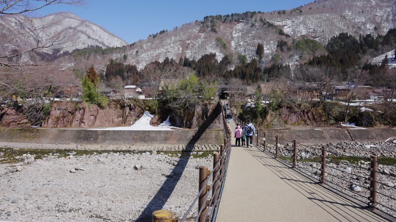 일본의 아름다운 기후 산, 관광객들이 시라카와고 마을로 다리를 건너다