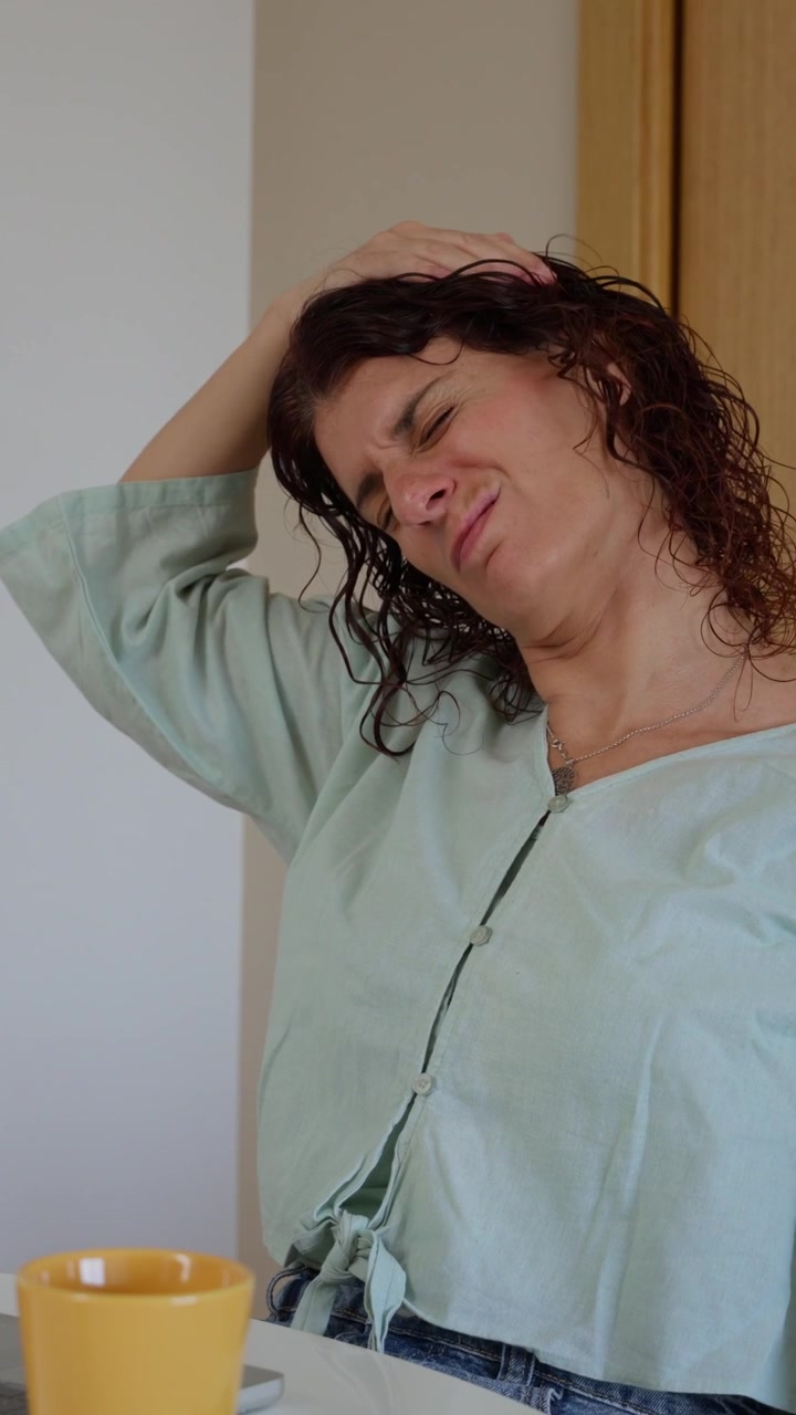Donna che fa stretching per collo e spalle alla scrivania