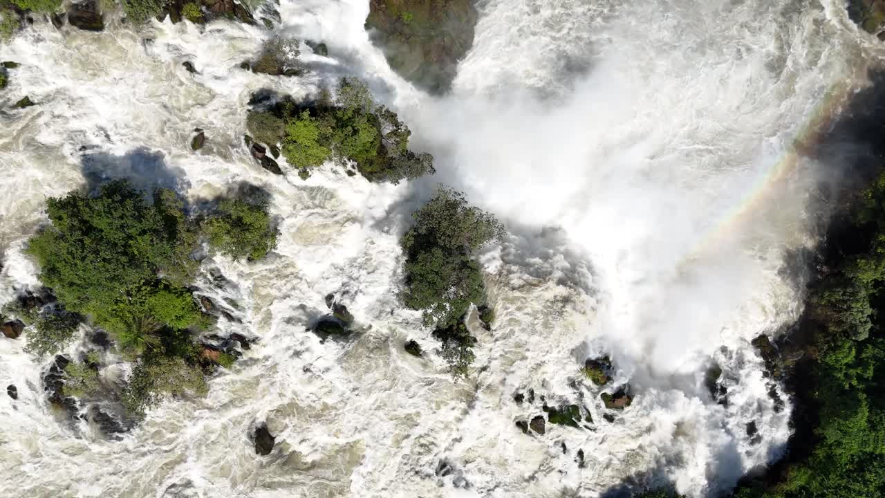Drone top-down view of Binga Falls in Angola, showing the raw power of cascading water and mist surrounded by dense tropical forest in a remote African setting