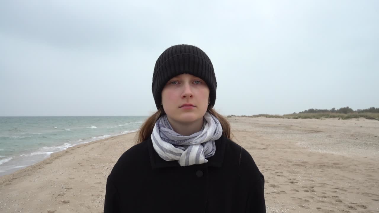 Pigen går på stranden. Optagelse på stranden.