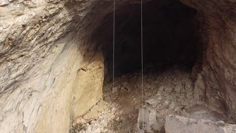 equipo de rescate bajando cuerdas por encima de la enorme entrada de una cueva