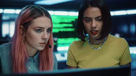 focused on the screen: two women collaborate in a high-tech cyber environment to solve complex problems, showcasing their determination and teamwork