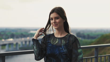 Coquettish-woman-in-elegant-outfit-near-handrail-in-city