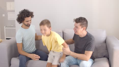 feliz niño alegre jugando y bailando en el sofá
