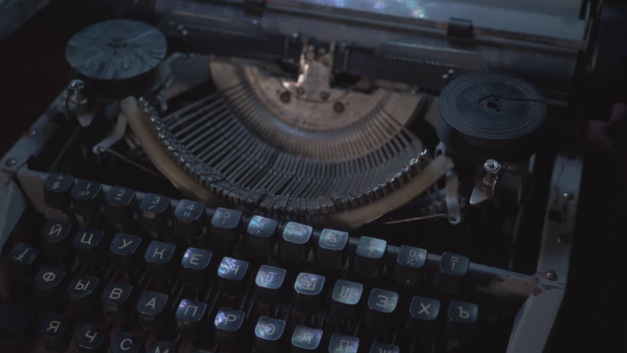 Uomo scrive con macchina da scrivere sovietica vintage al buio.