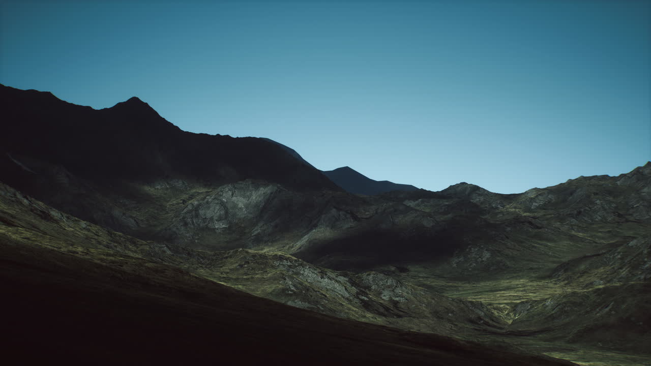 Mountainous landscape at twilight with rocky terrain and distant peaks