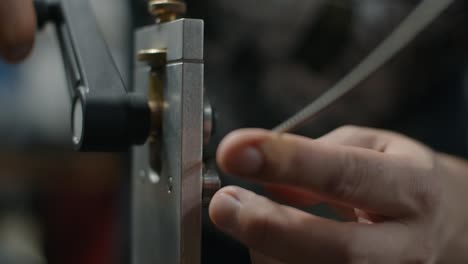 luthier utiliza fretbender para ajustar el radio del alambre del traste, preparaciones para el traste en el taller del fabricante de guitarras, 4k 60p prores hq