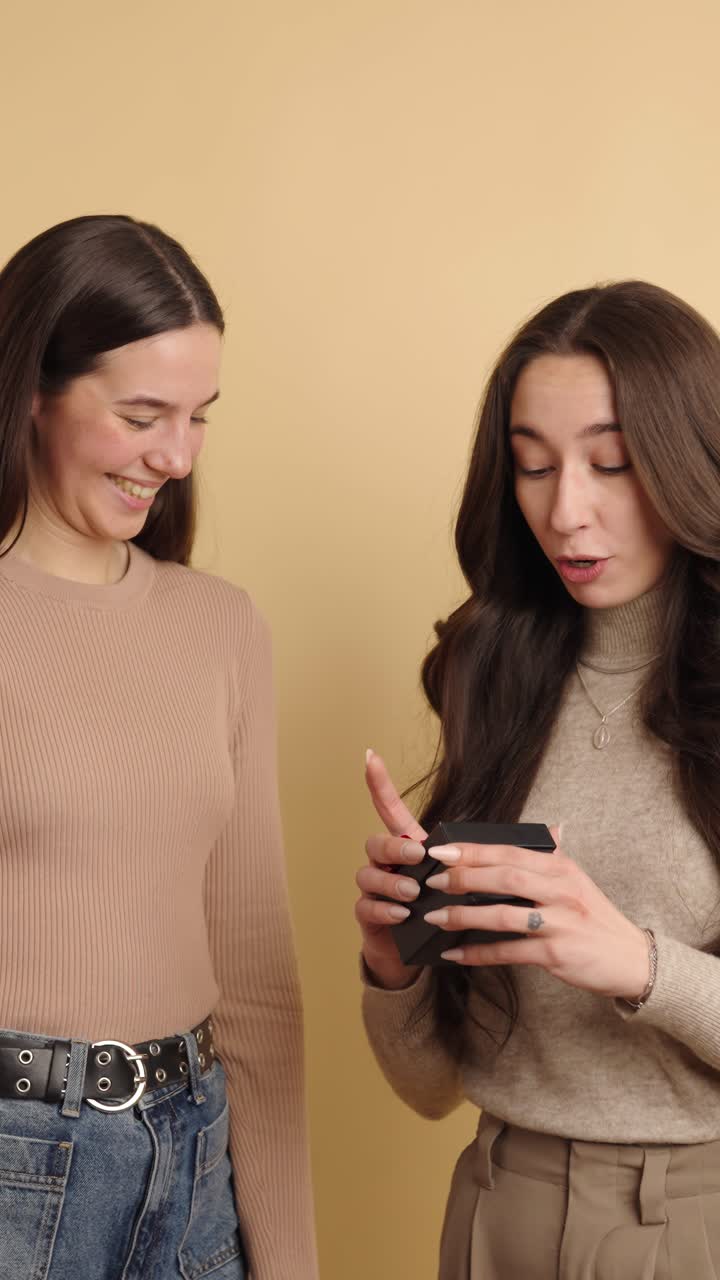 Young women sharing heartfelt moment with gift exchange