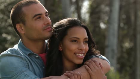 una joven pareja abrazándose y sonriendo.
