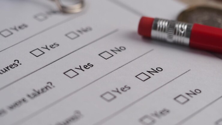 Hand Checking 'No' on a Paper Survey Form with a Red Pencil