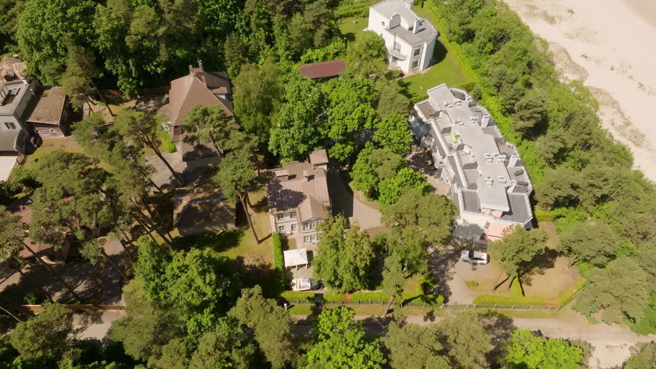 High angle drone shot circling condos and homes at a beach, summer day in Latvia