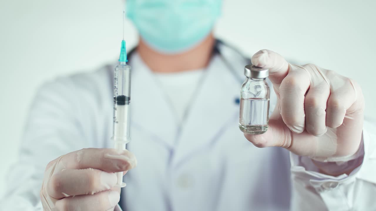 Doctor holding syringe and vaccine vial