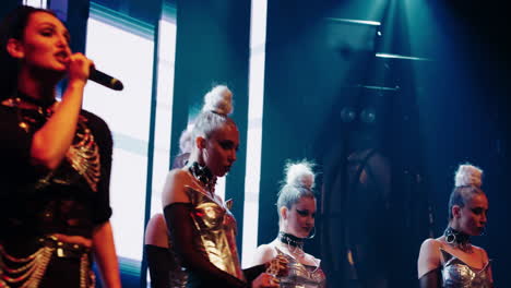 a group of female dancers perform on stage in front of bright lights.