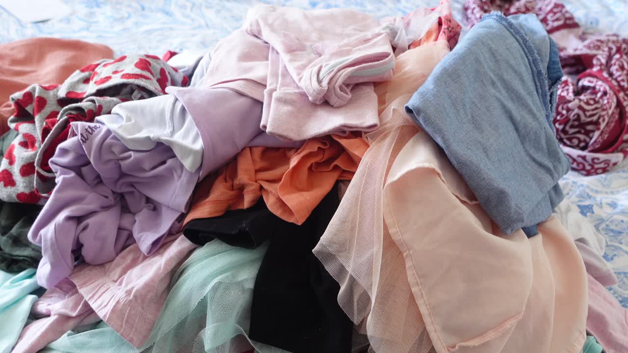 침대 위 에 있는 옷 어리