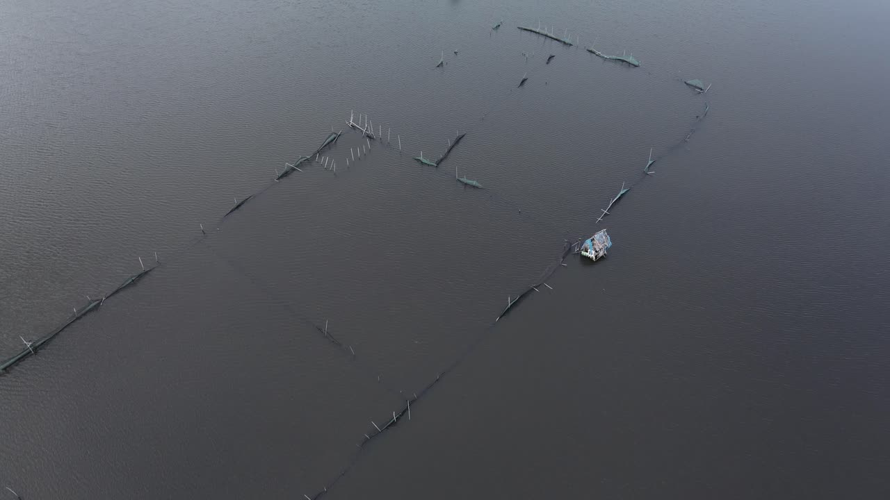 필리핀의 보홀에서 새벽에 물고기 농장 사이의 수로를 항해하는 단독 보트