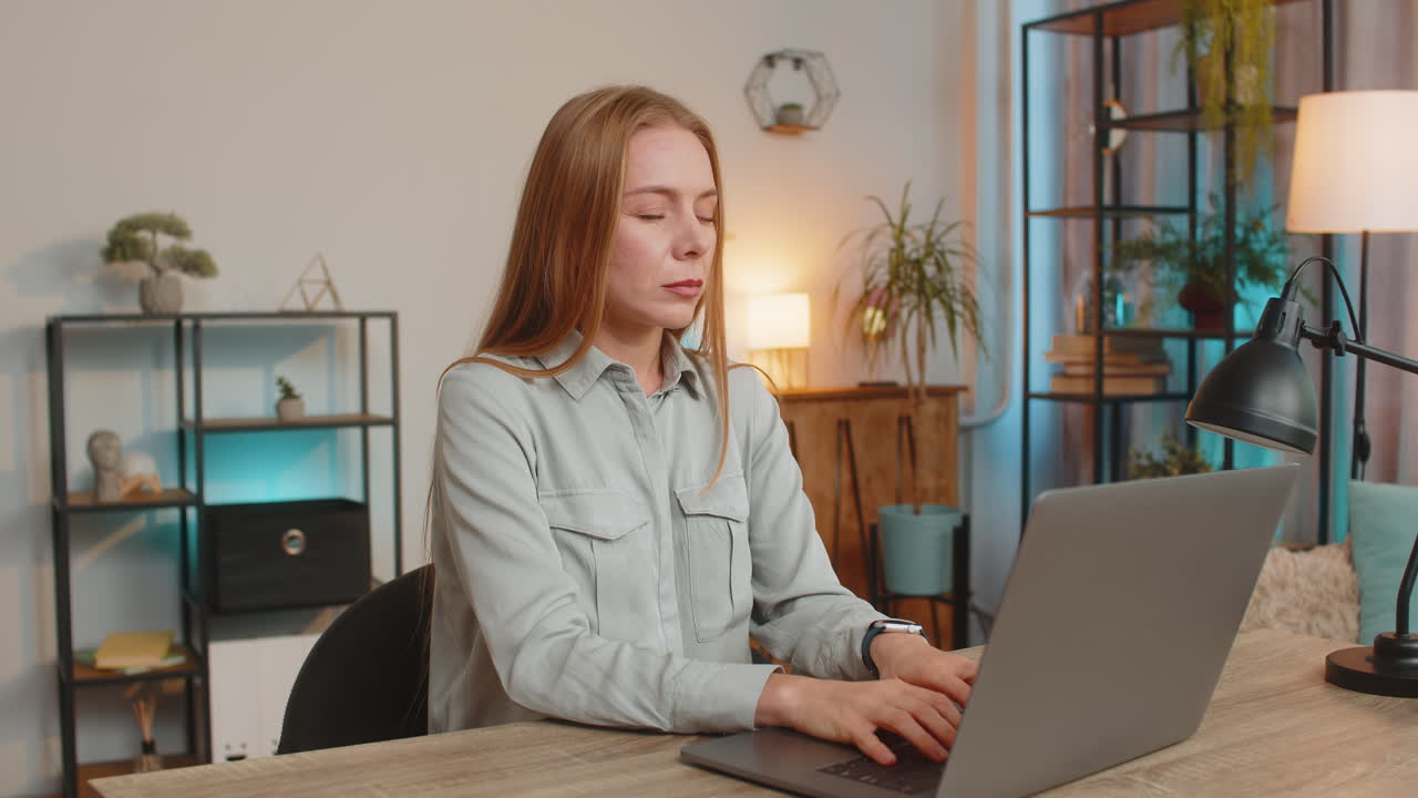 노트북을 사용하는 좌절 된 프리랜서가 집 사무실 테이블에 앉아 큰 소음으로 인해 일하기 위해 고군분투하고 있습니다.