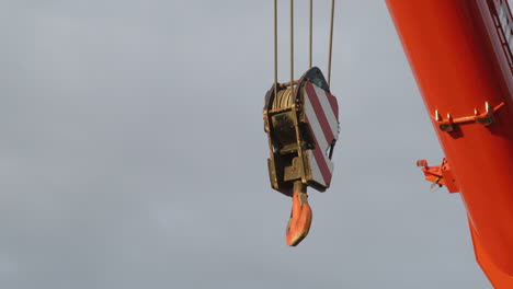 Close-up-shot-of-a-winch-of-a-crane-getting-pulled-high-into-the-air-on-a-construction-site