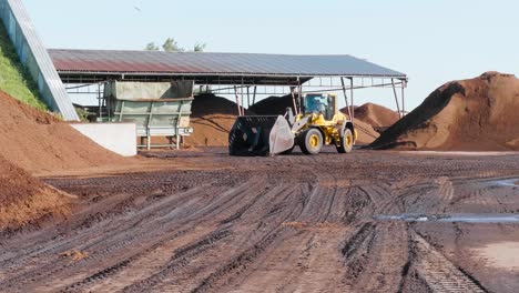 front loader truck shoving soil in peat processing plant
