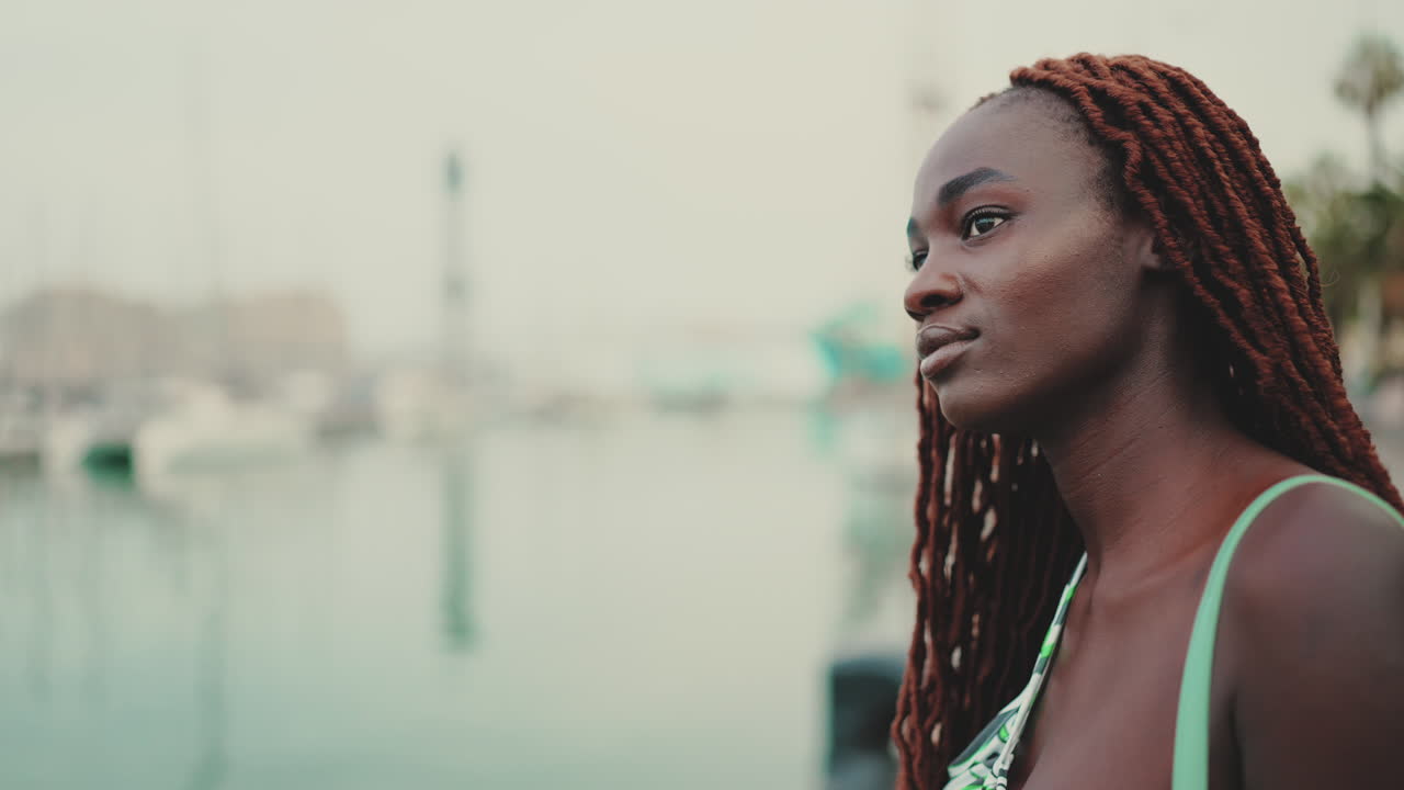 Ritratto di una donna con dreadlocks al mare