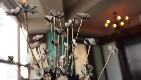 sfocare lo sfondo del caffè con un fiore sul tavolo