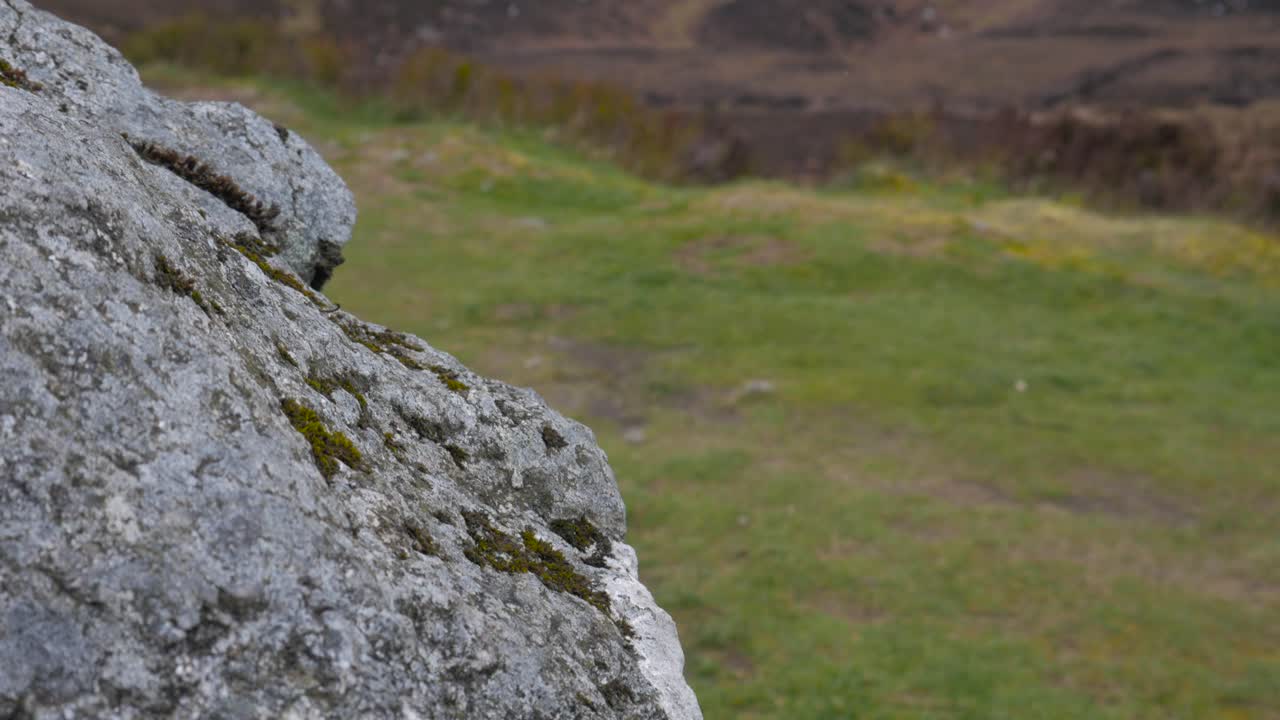 tiro de enfoque de tirón de estante inclinado, desde una roca gris hasta dos terceros lagos de fondo en wicklow, irlanda