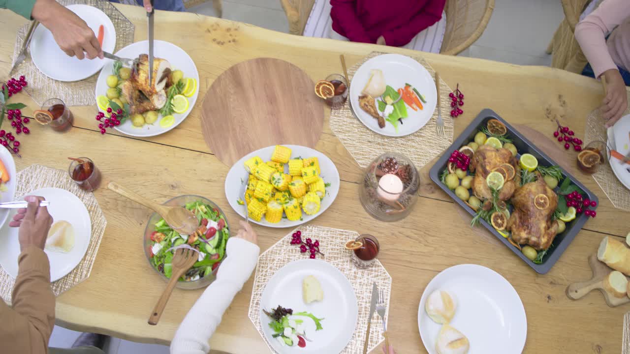 Hunger motivating diverse family passing veggies scooping corn carving turkey taking rolls at table