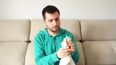 man covering an ice with a cloth to apply it on his face after wisdom teeth