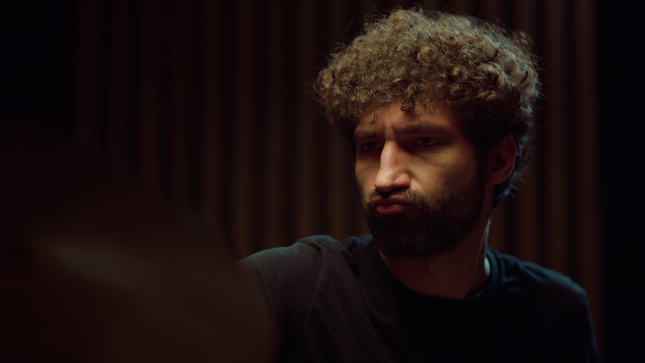 artista masculino tocando la batería en el interior. músico expresivo actuando en solitario.