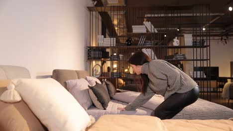 selection of upholstered furniture in a furniture salon selection of upholstered furniture in a furniture salon an attractive fashionable woman chooses a bed for comfort and softness the choice of comfortable furniture for life