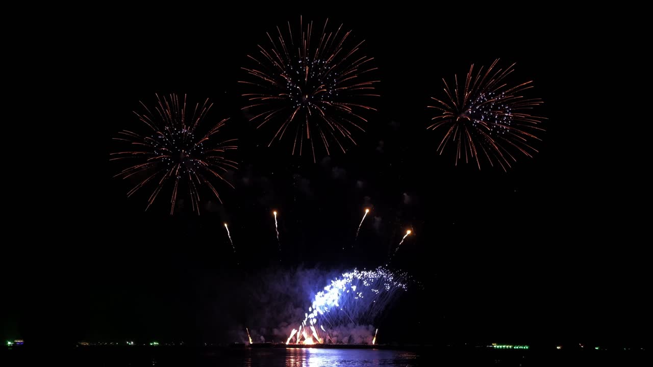 personas viendo fuegos artificiales épicos en la playa