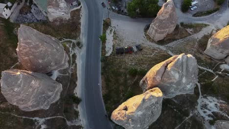 top-down view of a busy street between cone-shaped rock formations in cappadocia, turkey