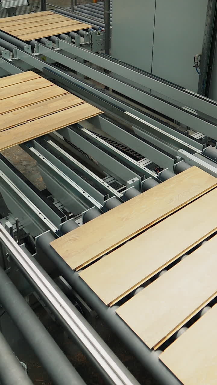 wooden boards are processing at the automated line of plant for the parquet manufacturing. Woodworking industry. Vertical video