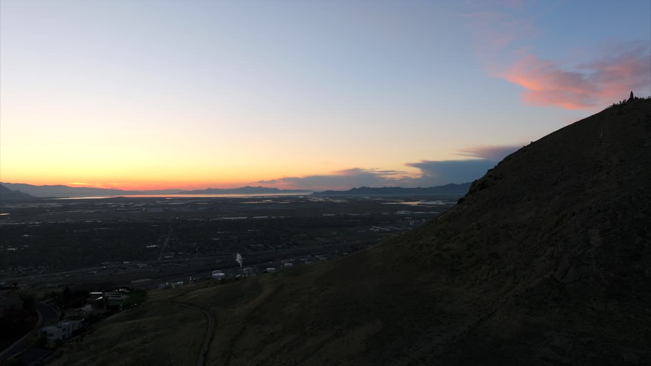 drone que se eleva en la colina con el área industrial de salt lake city en el fondo al atardecer, utah en estados unidos