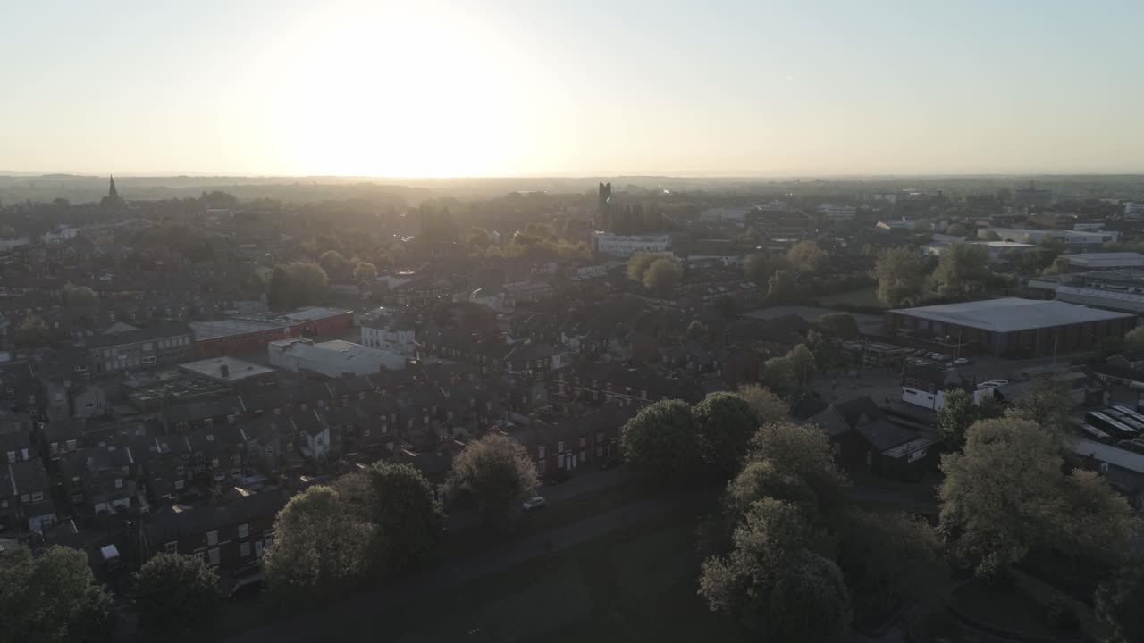Drone aerial view rising above British sunrise typical housing silhouette skyline