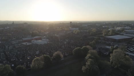 drone aerial view rising above british sunrise typical housing silhouette skyline