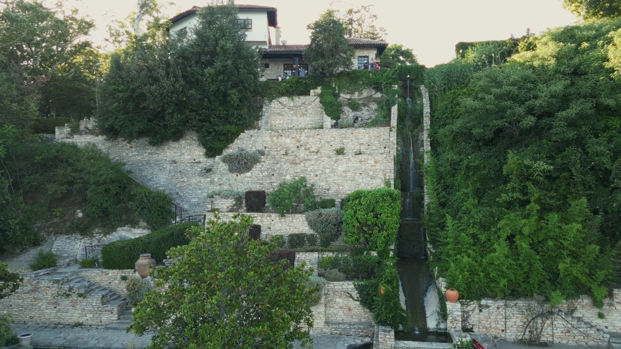 Waterfalls In The Botanical Gardens Of Balchik Palace During Sunrise In Bulgaria. Aerial Shot