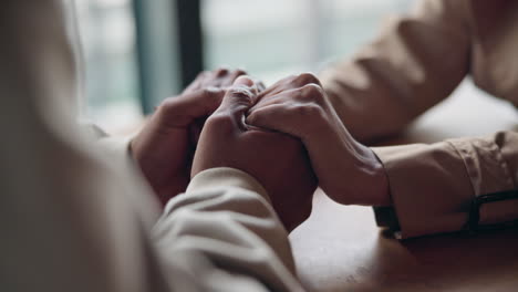 teniendo las manos, el apoyo y la pareja en la mesa