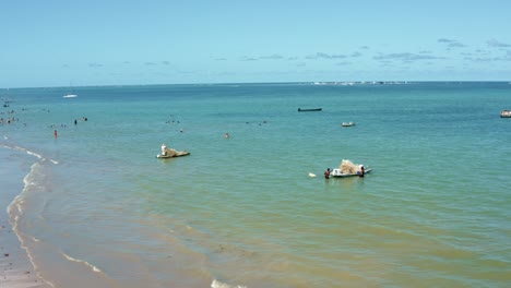 Dolly-En-Toma-Aérea-De-Pequeños-Barcos-De-Pesca-Que-Se-Preparan-Para-Zarpar-En-La-Orilla-De-La-Playa-De-Bessa-En-La-Capital-Tropical-Joao-Pessoa,-Brasil-En-El-Estado-De-Paraiba-En-Un-Cálido-Día-Soleado-De-Verano