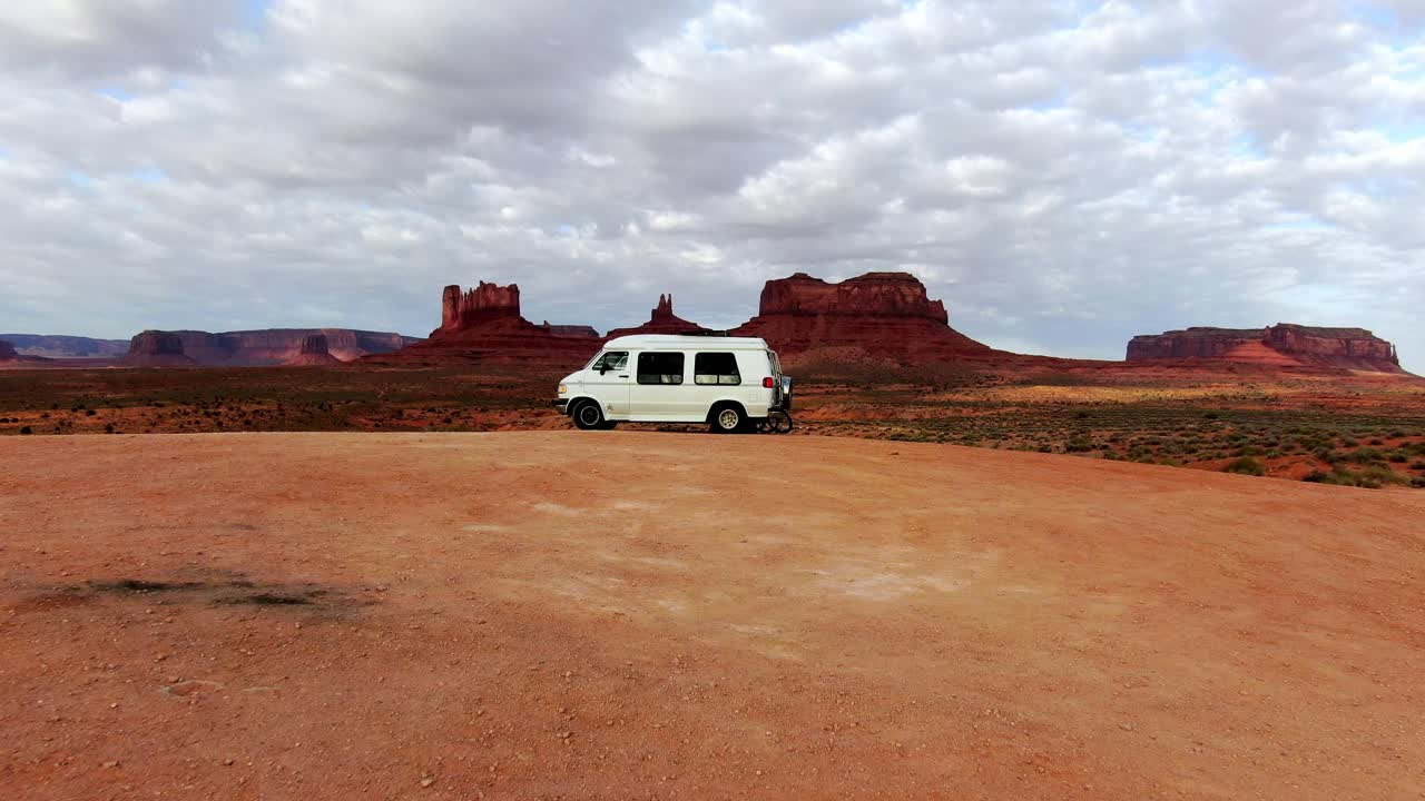 밴 구명가와 모뉴먼트 밸리에서 운동하는 여성을 향해 날아가는 드론 샷