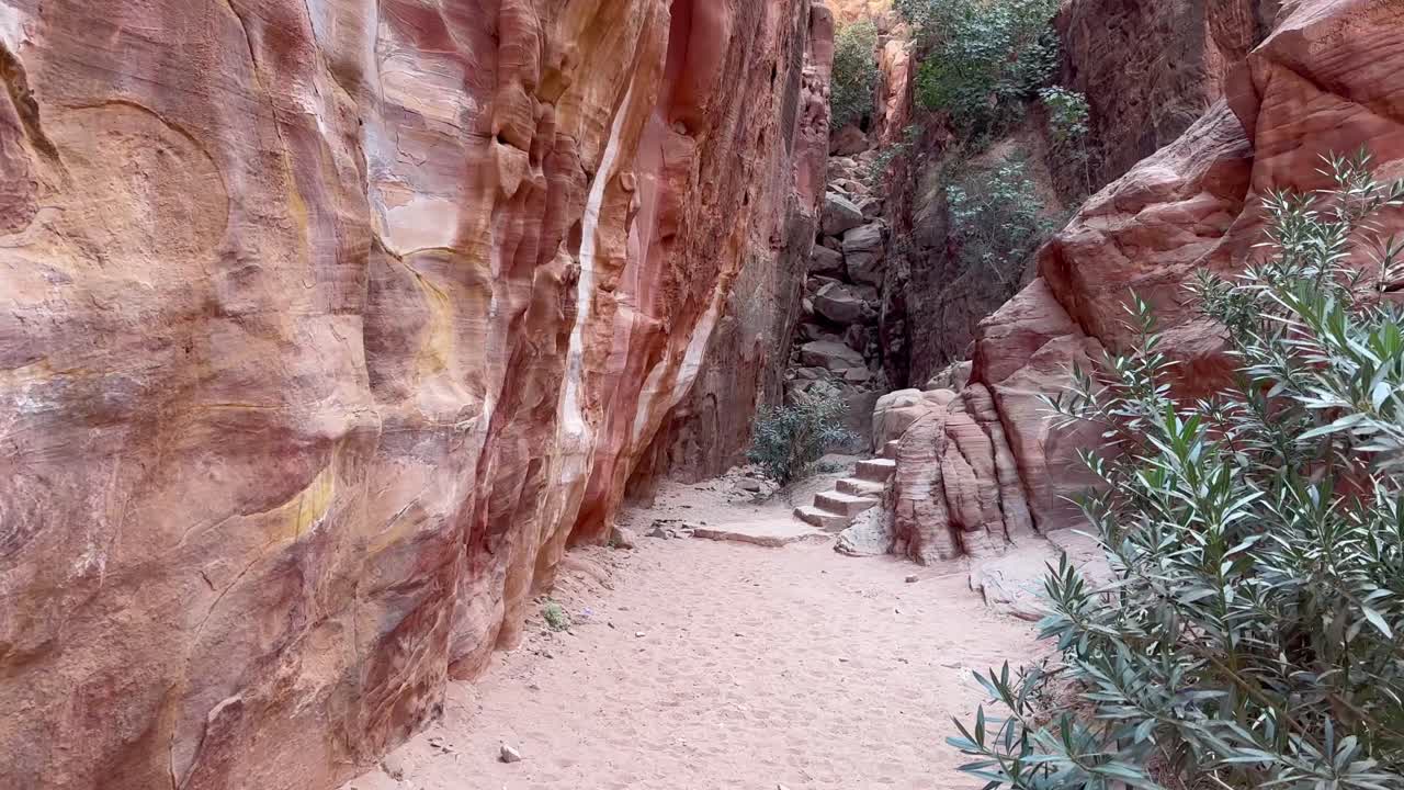 caminando por un camino en petra, jordania para encontrar antiguas escaleras talladas en la piedra arenisca