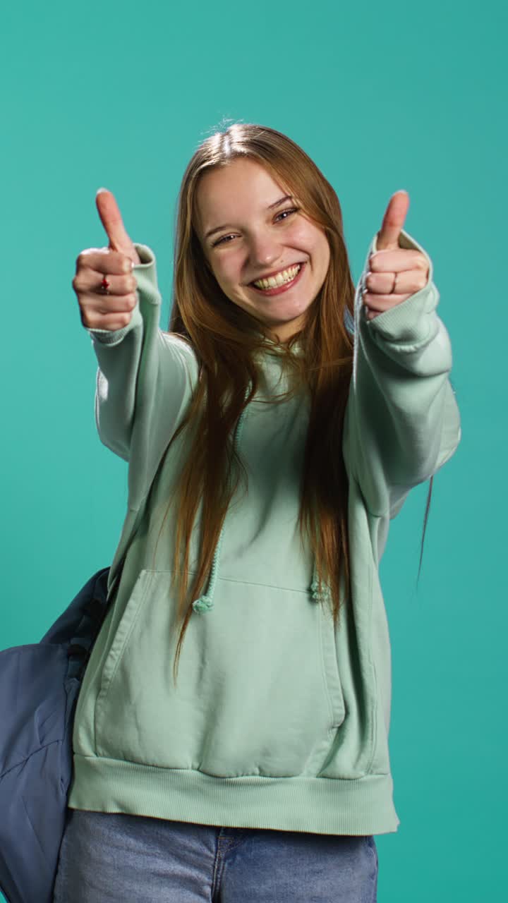 Vertical video Happy girl doing thumbs up hand gesturing, showing approval