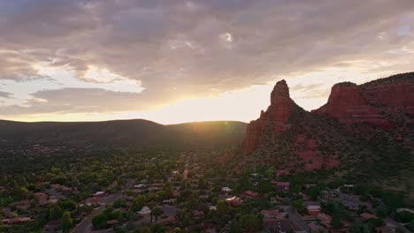 drone ascends over suburb of sedona arizona as sunset spreads golden light