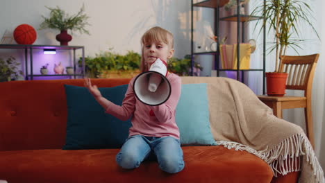child girl kid standing on sofa at home alone loudly shout in megaphone announces discounts sale